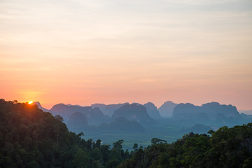 Fototapeta na wymiar Beautiful landscape with dramatic sunset, tropical rainforest and steep mountain ridge on horizon. Krabi, Thailand