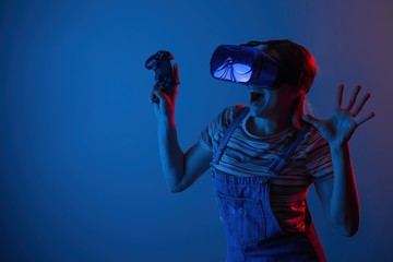 Young cute girl playing vr. with creative blue-red light. it is emeanantly and fun