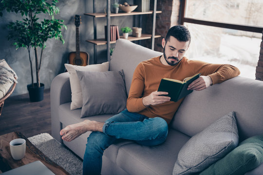 Portrait of handosme focused pensive man hold hand have recreation she heis vacation sit divan comfy wear  denim jeans pullover sweater apartment 