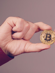 Man hand holding golden bitcoin