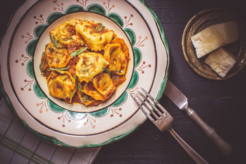 Tortellini with Tomato Sauce, Mozzarella Cheese and Basil on Rustic Plate