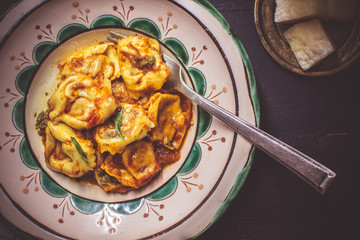 Tortellini with Tomato Sauce, Mozzarella Cheese and Basil on Rustic Plate