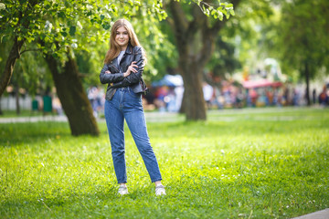portrait of little beautiful stylish kid girl in city park on green forest background