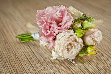 A small bouquet of flowers on a wooden table. Wedding bouquet for the groom.