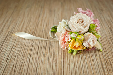 A small bouquet of flowers on a wooden table. Wedding bouquet for the groom.