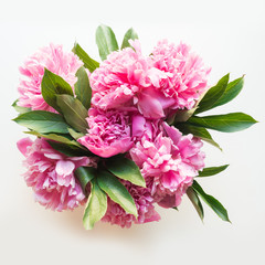 Bouquet of pink peony flowers on white. Copy space for text. Top view.