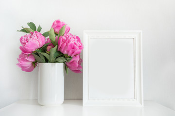 Bouquet of pink peony in vase with photo frame for text on white. Mothers day.