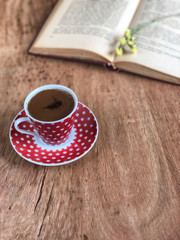 an old book and cup of coffee on wooden table