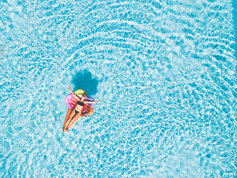 Beautiful Young Woman Lay Down Enjoying And Relaxing On An Inflatable Ice Cream Lilo In A Blue Clear Swimming Pool - Holiday Summer Vacation At Hotel Resort Concept For People Having Fun