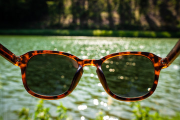 Lake view trough sunglasses lens on a sunny summer day during travelling
