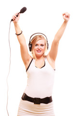 Woman singing to microphone wearing headphones