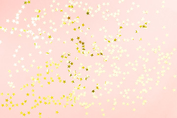 Holographic stars and gold sparkles on pastel pink background. Festive backdrop for your projects