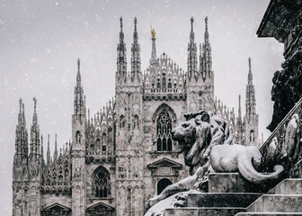 Snow falling at Piazza del Duomo in Milan, Lombardy, Italy with Milan's landmark Cathedral in...