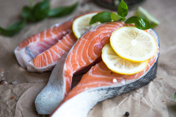 Salmon. Raw Trout Red Fish Steak served with Herbs and Lemon. Cooking Salmon, sea food. Healthy eating concept