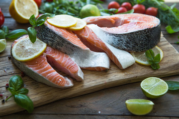 Salmon. Raw Trout Red Fish Steak served with Herbs and Lemon. Cooking Salmon, sea food. Healthy eating concept