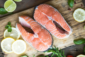 Salmon. Raw Trout Red Fish Steak served with Herbs and Lemon. Cooking Salmon, sea food. Healthy eating concept
