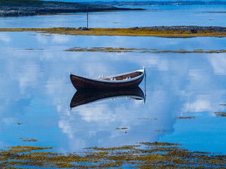 Seascape with rowing boat and calm waters.