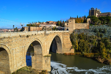 Fototapeta premium Ancient stone bridge with arches across the river Tagus in Toledo.