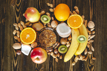 Healthy vegan raw foods on wooden background. Fruits and nuts on the table pile. Natural organic sweet dessert