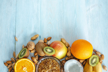 Healthy vegan raw foods on blue background. Fruits and nuts on the table. Organic sweet dessert. Place for text