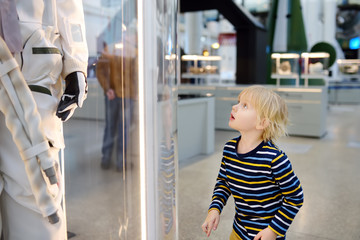 Little caucasian boy looking astronaut space suit in museum © Maria Sbytova