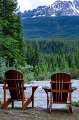 Obraz na płótnie Canvas 2 Seater Wood Adirondack Chairs buy a river in the canadain rockies