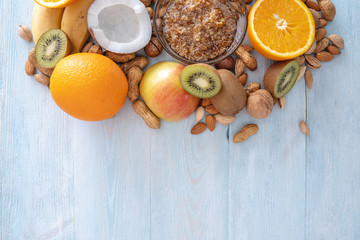Fototapeta na wymiar Healthy vegan raw foods on blue background. Fruits and nuts on the table. Organic sweet dessert. Place for text