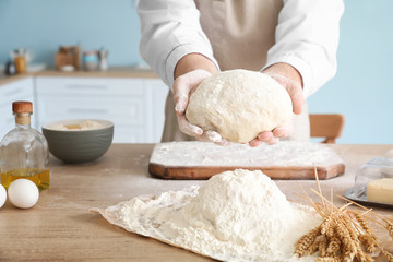 Chef with raw dough in kitchen