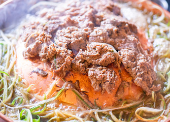 Beef barbecue bulgogi in Korean restaurant in Seoul, lifestyle fresh korean food cuisine on copper pan with sliced green onion, close up, copy space