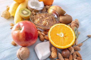 Healthy vegan raw foods on blue background. Fruits and nuts with honey on the table. Natural organic sweet dessert.