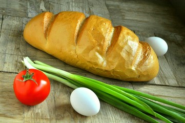 bread onion eggs and tomato on a wooden background