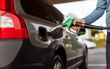 Crop man refueling car on filling station