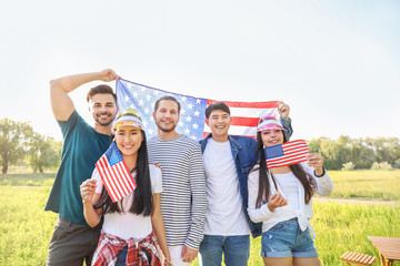 Young people with USA flags outdoors. Independence Day celebration