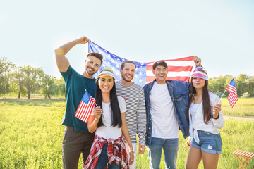 Young people with USA flags outdoors. Independence Day celebration