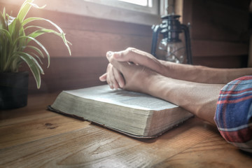 focus at beside of holy Bible with hands praying background.