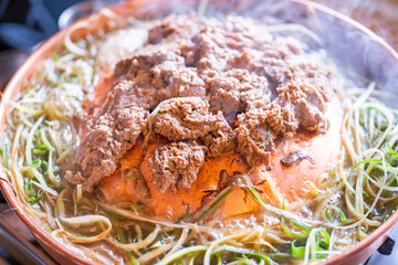 Beef barbecue bulgogi in Korean restaurant in Seoul, lifestyle fresh korean food cuisine on copper pan with sliced green onion, close up, copy space