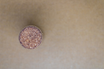 Fototapeta na wymiar One wine cork stopper on blurred brown background top view - Image