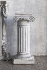 Stone column on light gray background. Close-up, copy space, front view, vertical format
