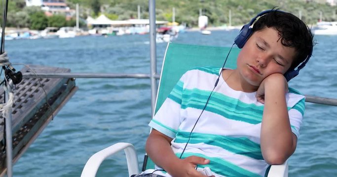 Portrait of a young boy with headphone on boat
