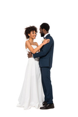 cheerful african american bridegroom and bride hugging isolated on white