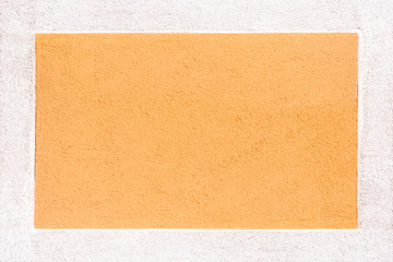 Eine orange Steinmauer mit weißen Rahmen als Hintergrund