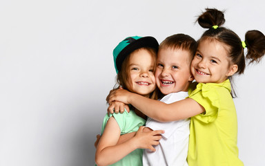 Studio portrait of children on a light background: full body shot of three children in bright...