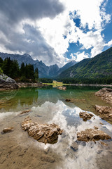 Fototapeta na wymiar The small Fusine Lake (Lago di Fusine) and the Julian Alps, Mount Mangart, Tarvisio, Friuli Venezia Giulia, Italy, Europe