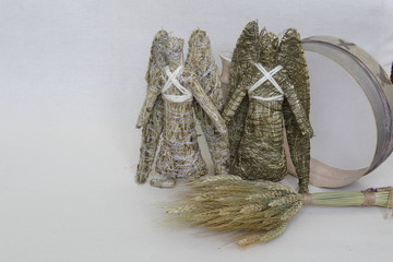 An amulet of dolls holding an angel from hay and a dry flower of handmade. Dry shoots, wheat, rye. The concept of goodness, wealth, crop.