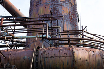 Colorful metal patina on rusting pipes and furnace, steel mill, horizontal aspect
