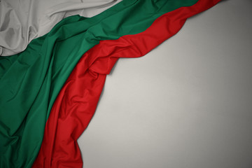 waving national flag of bulgaria on a gray background. - obrazy, fototapety, plakaty
