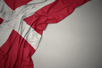 waving national flag of denmark on a gray background.