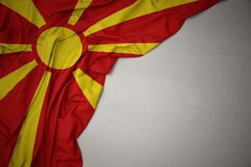 waving national flag of macedonia on a gray background. - obrazy, fototapety, plakaty
