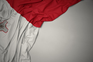 waving national flag of malta on a gray background. - obrazy, fototapety, plakaty