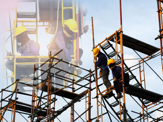 Construction workers working on scaffolding,Man Working on the Working at height with blue sky at construction site